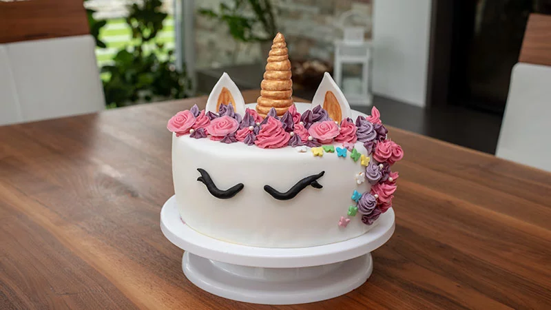 Unicorn cake with golden horn and piping decoration