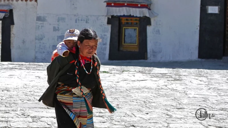 Tibetische Mutter mit Kind in Tracht